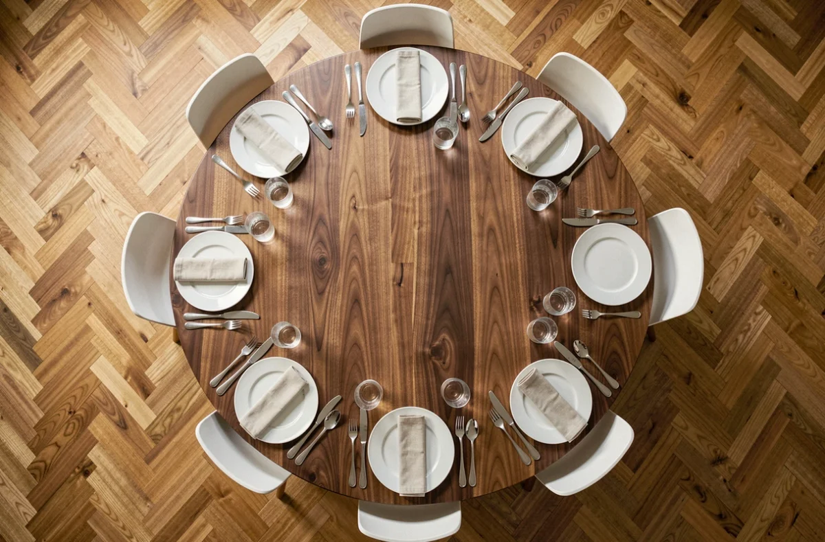 Vue aérienne d'une table ronde dressée pour 6 personnes illustrant les espacements et dimensions idéales des couverts